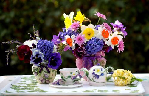 Изображение с двумя вазами цветов на обеденном столе