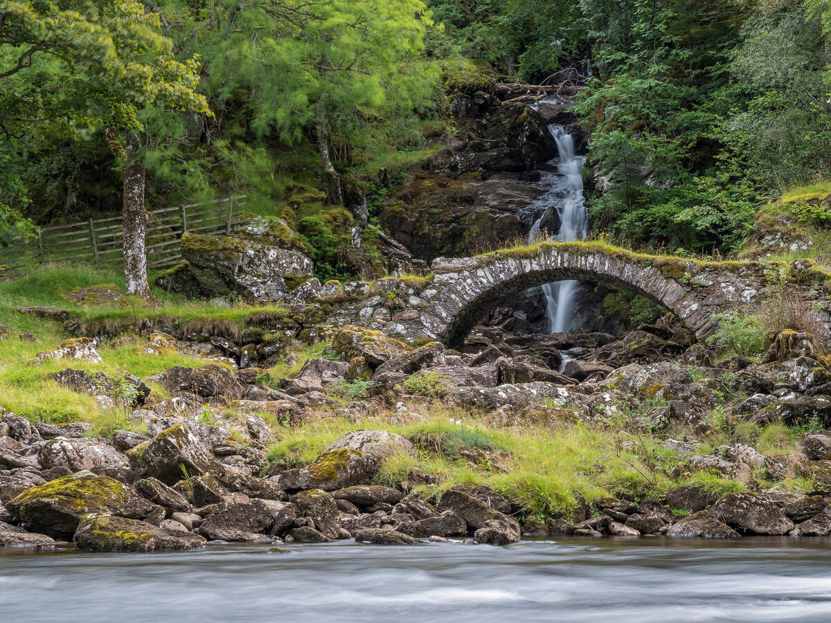 Stone bridge over a waterfall in Scotland