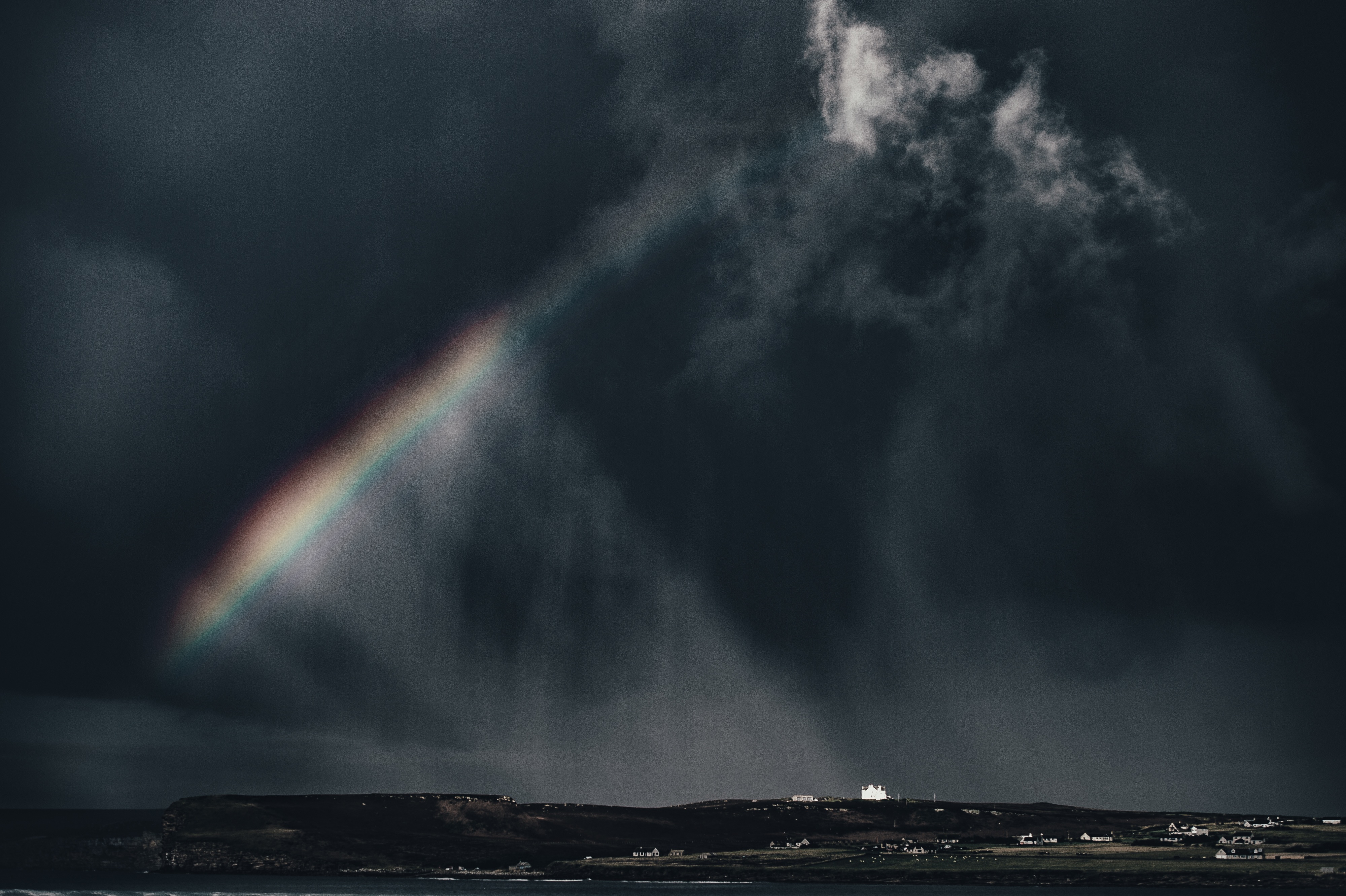 Бесплатное фото Радуга на тёмном небе во время шторма