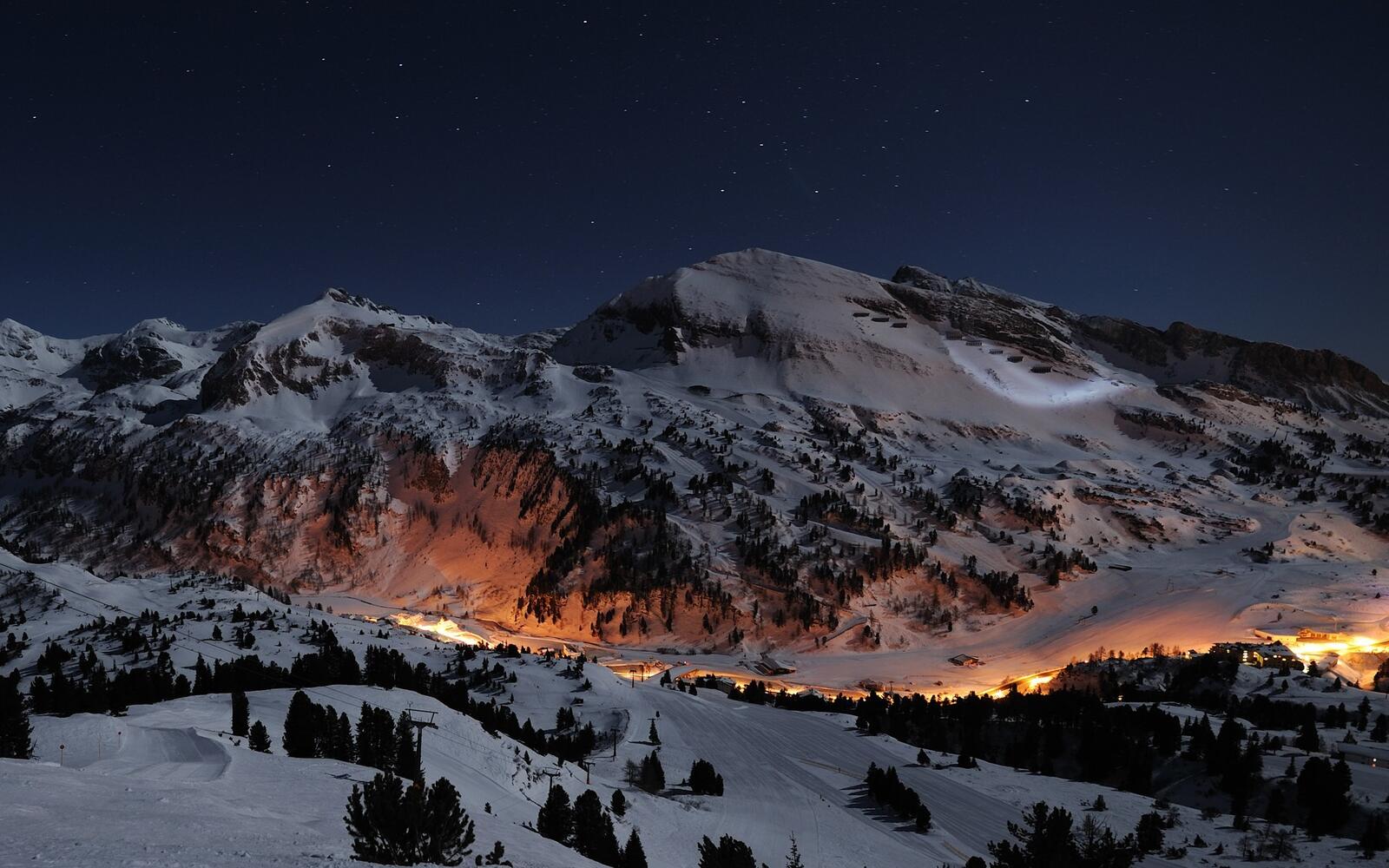 Бесплатное фото Картинка с поселением среди снежных ночных гор