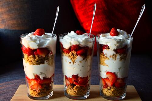 A delicious dessert with strawberries and cream in a large glass