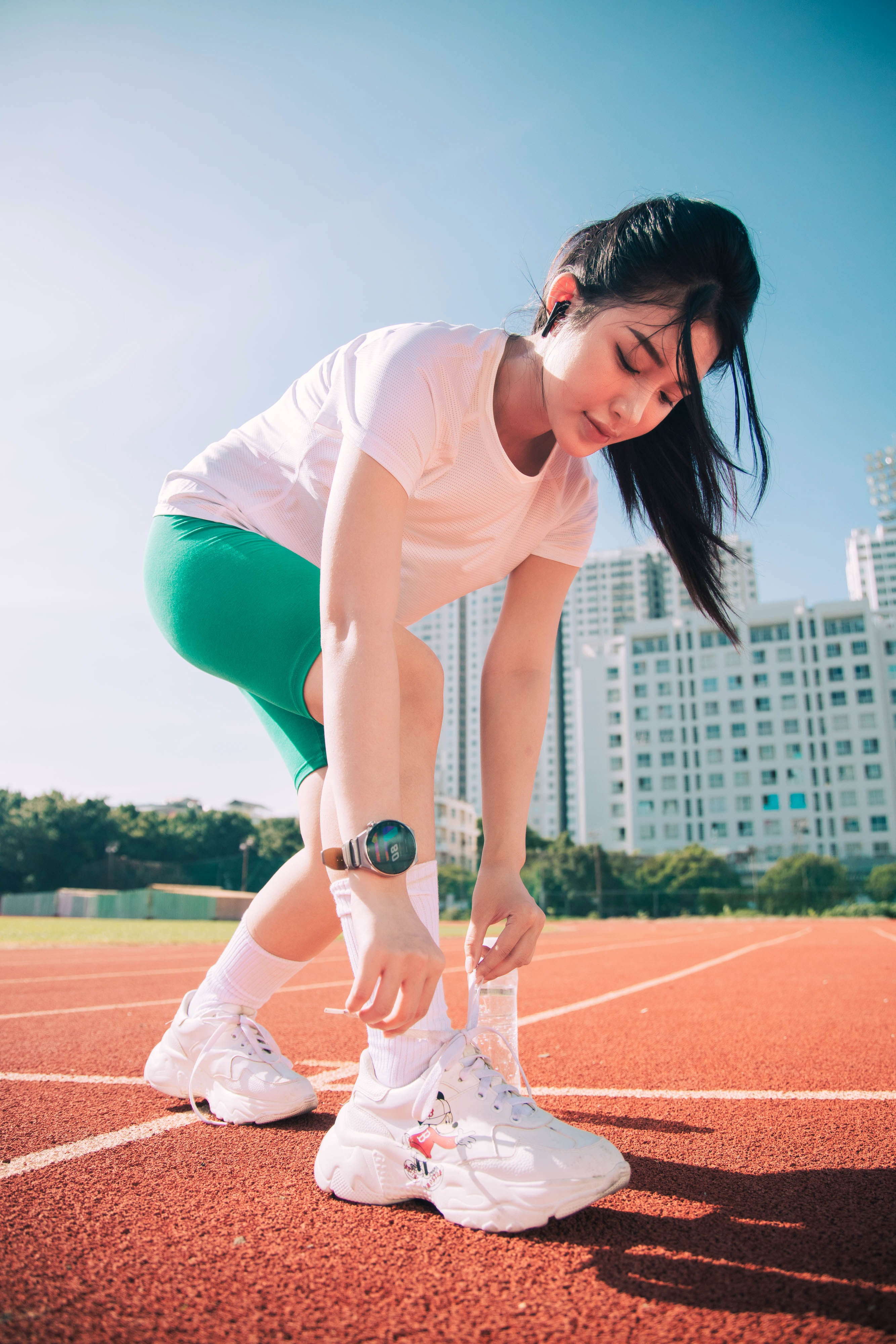 Бесплатное фото Черноволосая азиатка в белых кроссовках занимается спортом