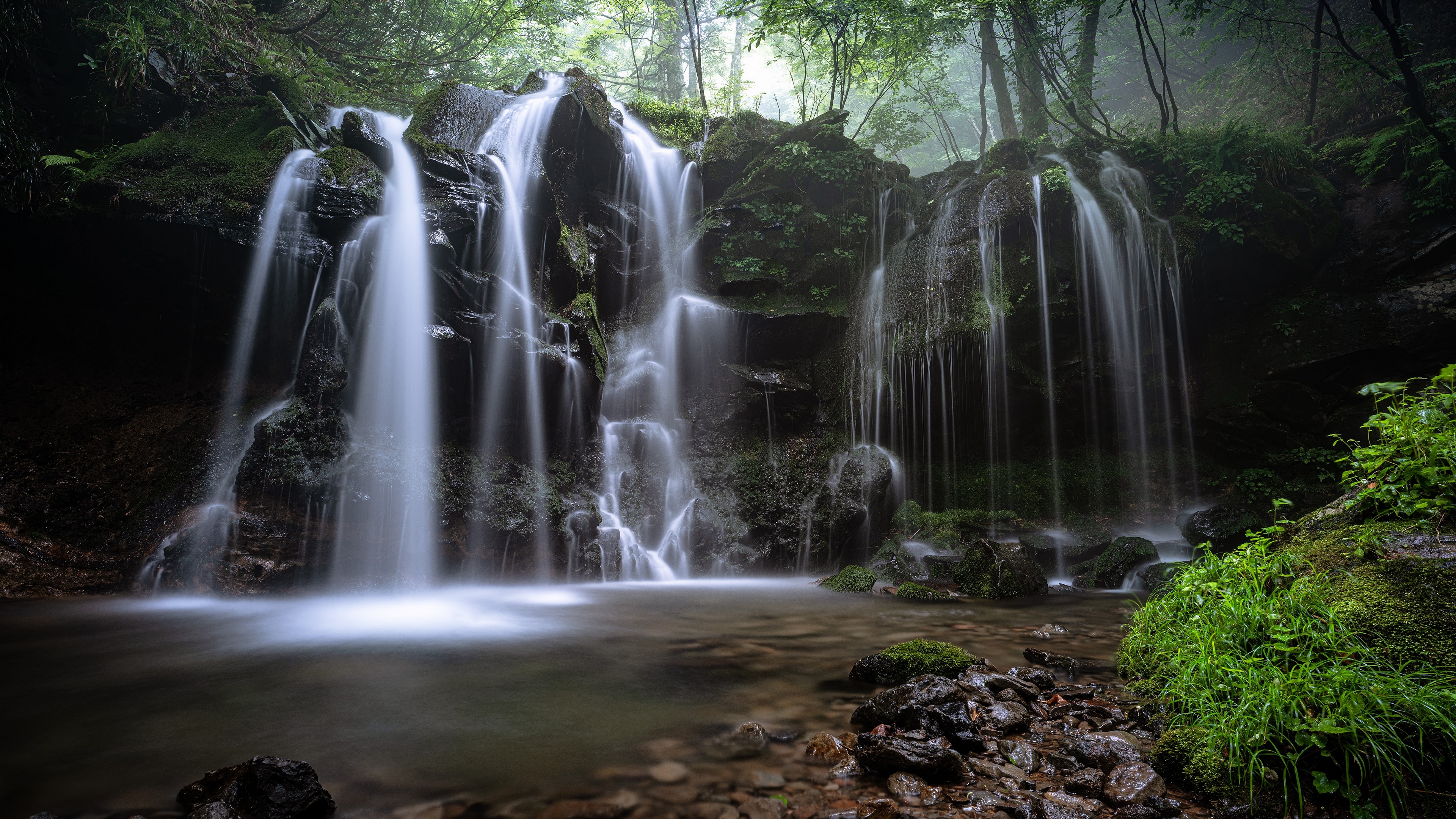 Водопад в лесу в скалистой местности