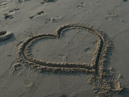 Сердечко на песочном берегу пляжа