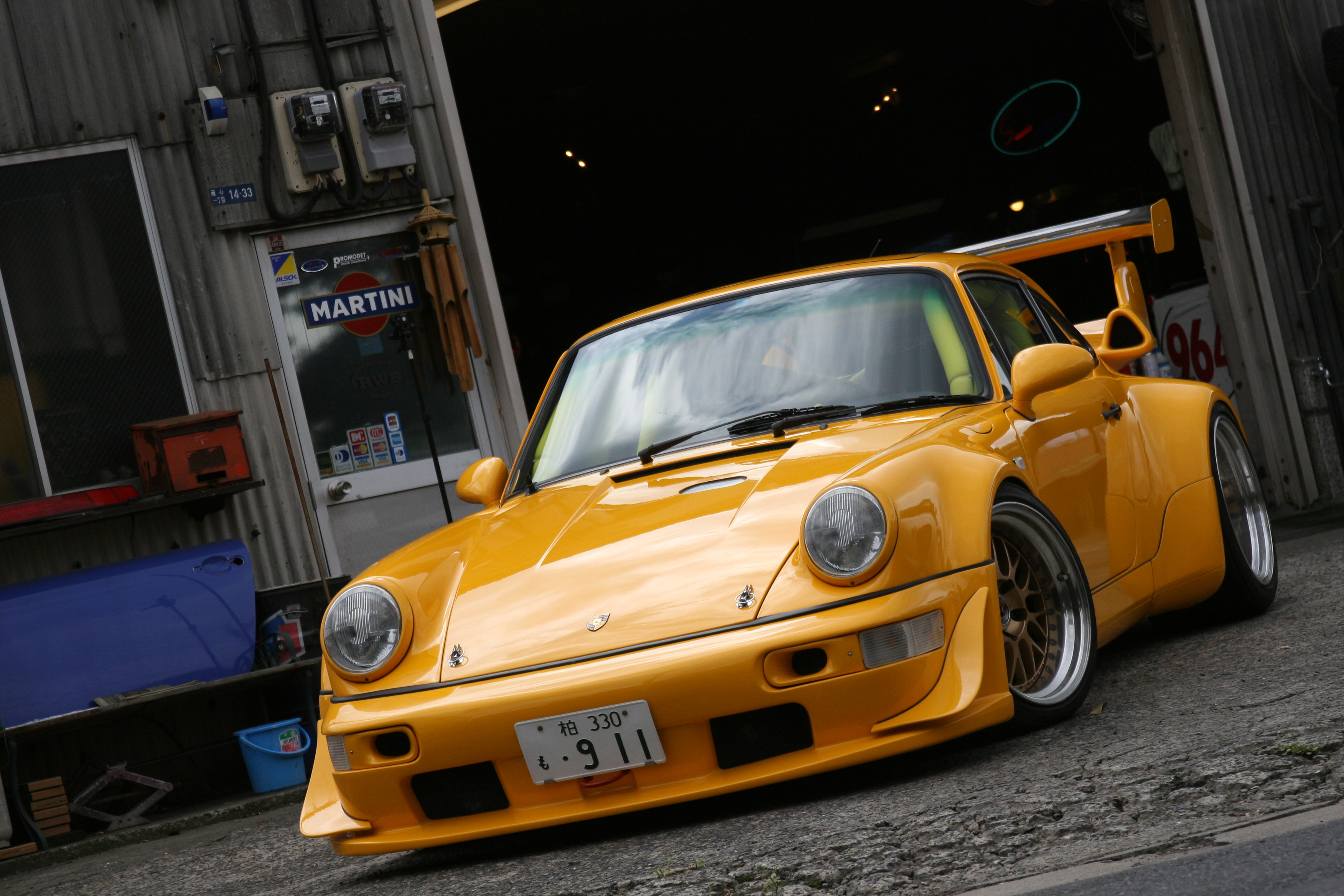 A yellow Porsche 911 with a big spoiler.