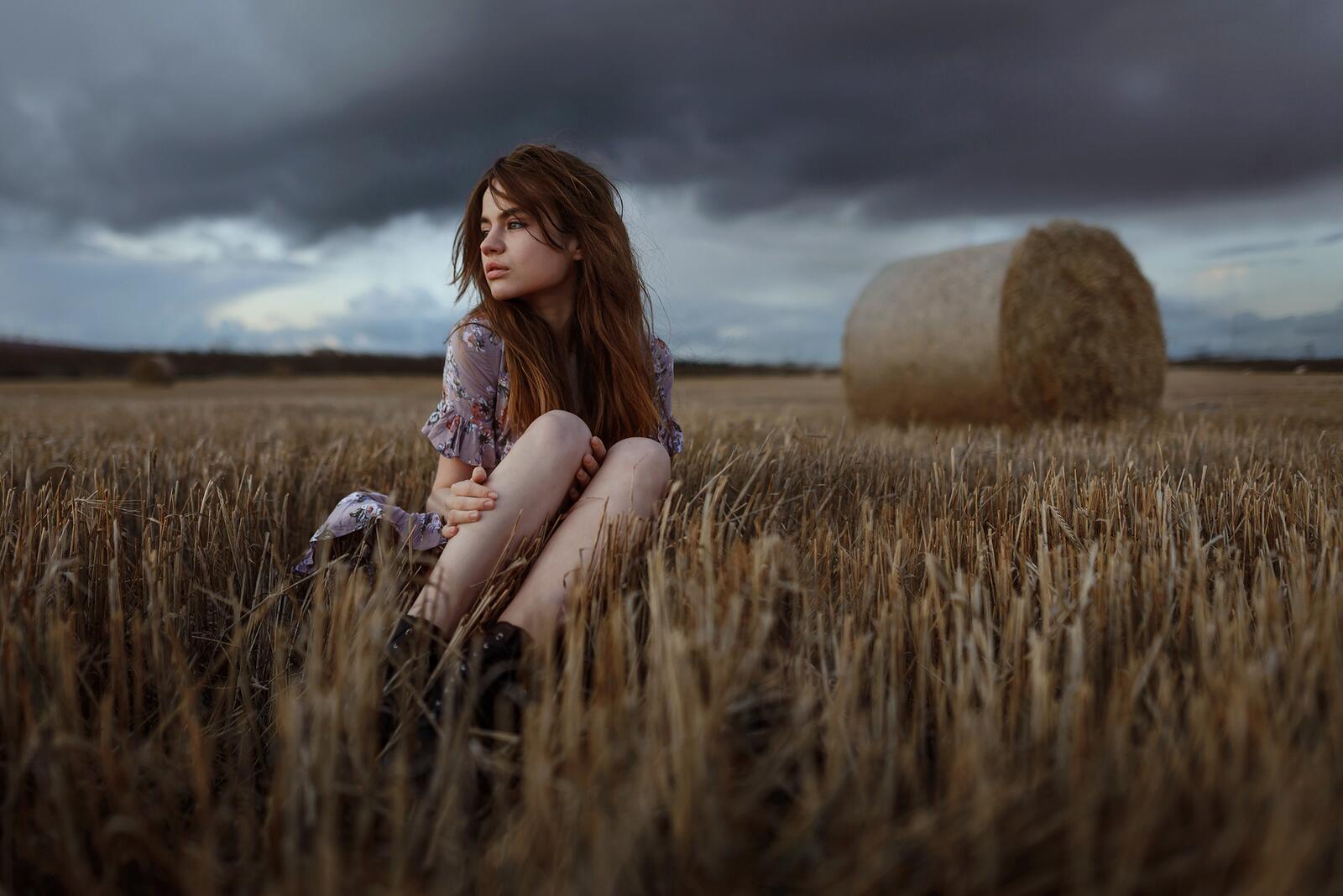Free photo Redheaded model on the background of hay rolls