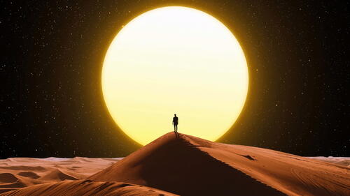 A man standing on a desert barchan at night.