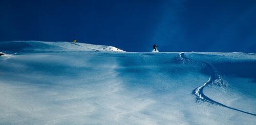 Сноубордисты спускаются по снежному склону