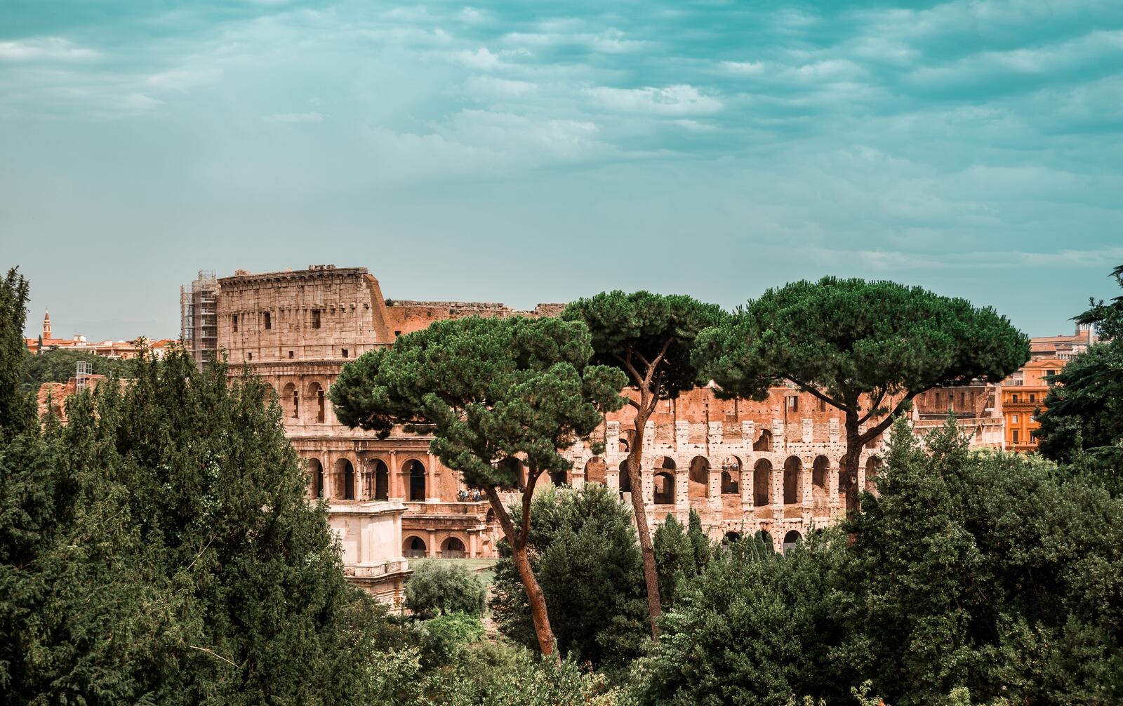 Бесплатное фото Колизей в Риме с зелеными деревьями