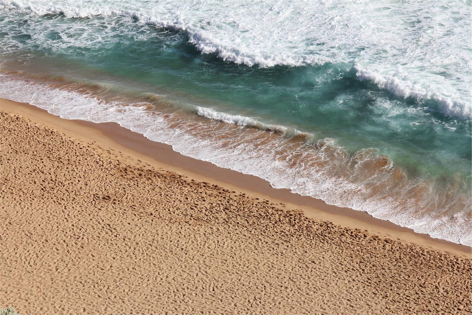 Изображение волны омывающий песочный берег пляжа