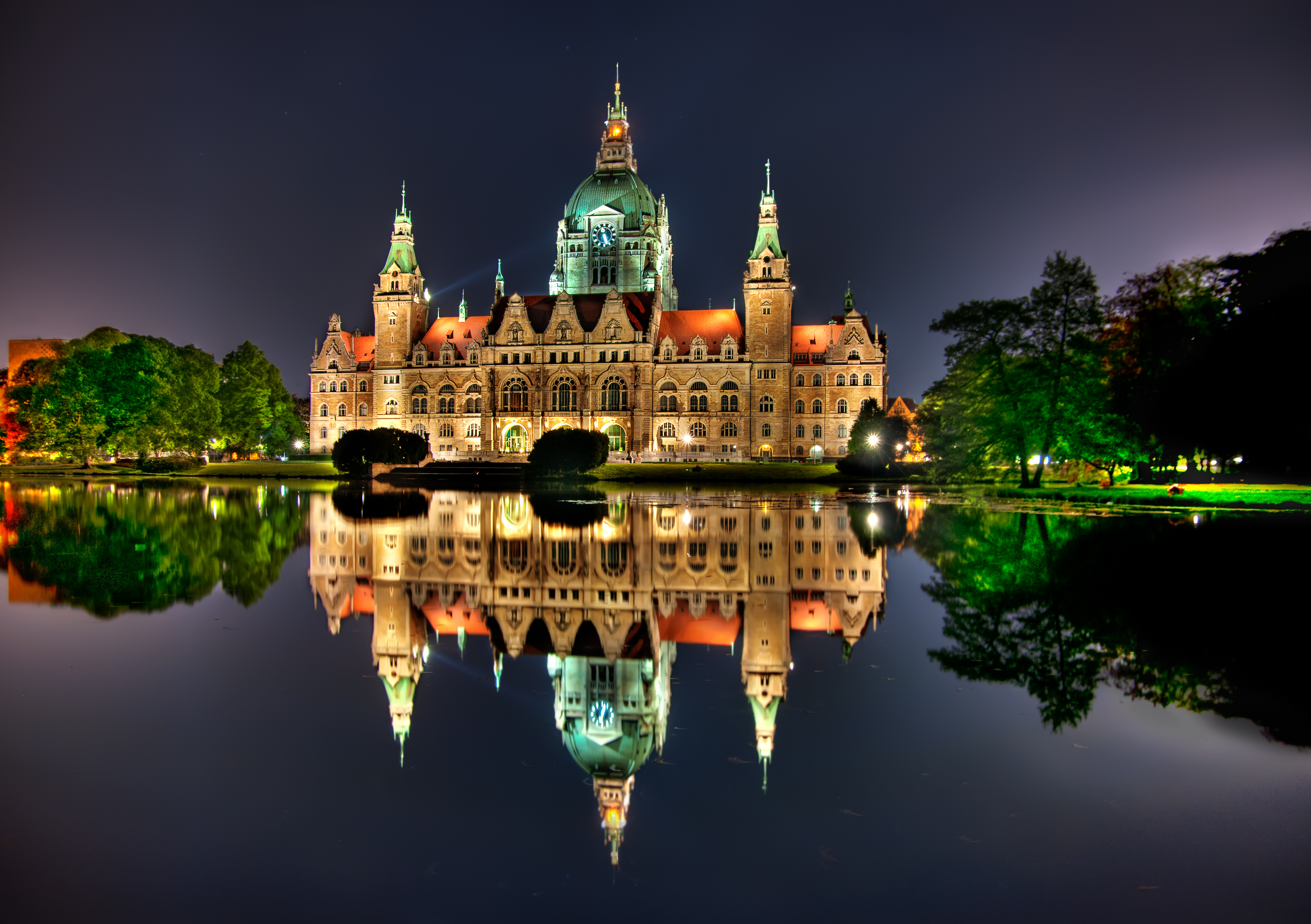 The glowing building is reflected in the lake at evening time