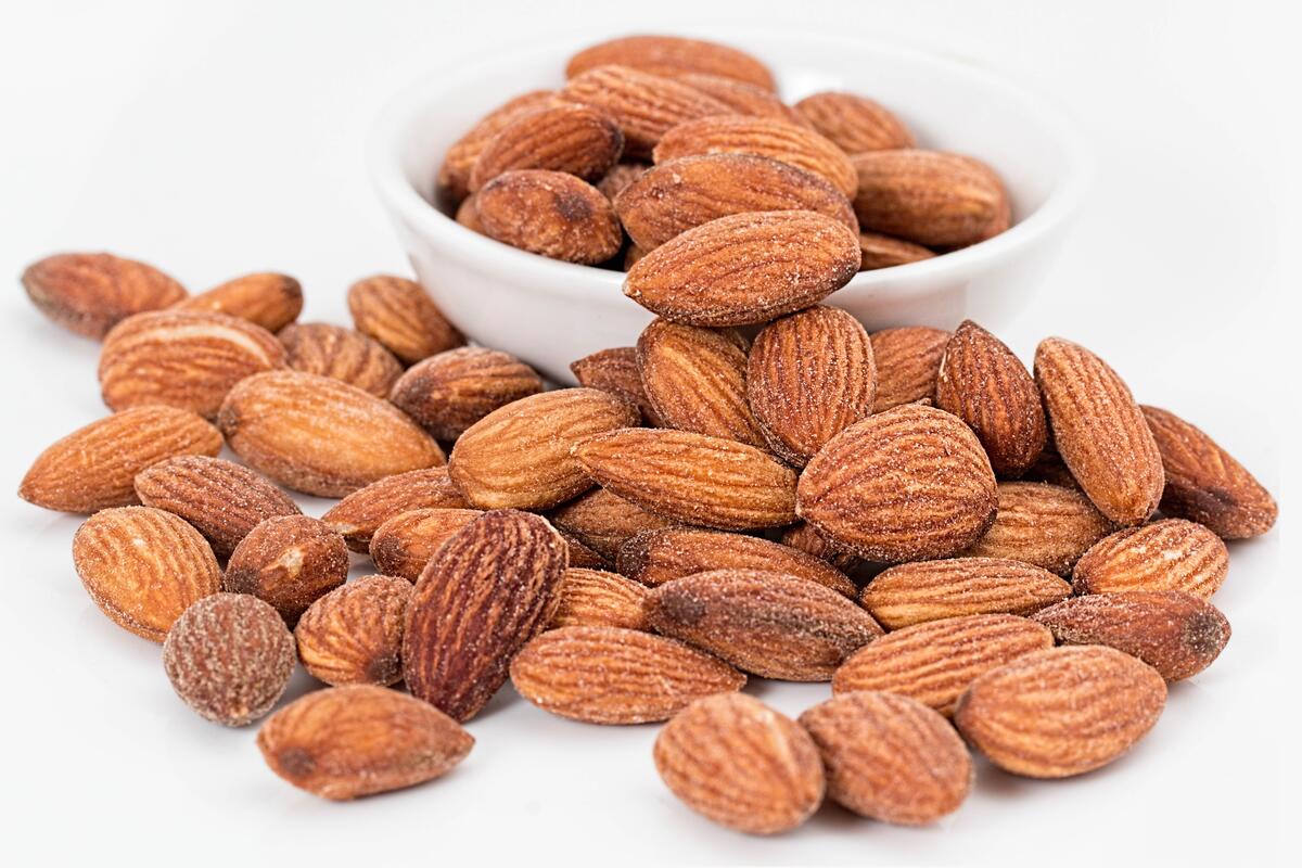 Scattered almond nuts on a white background